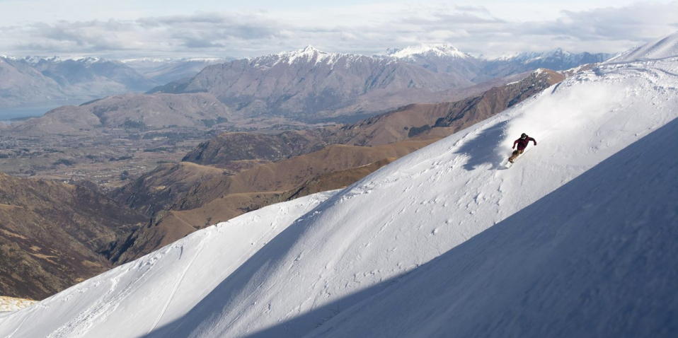 Snowboarder with mountain backdrop at Cardrona Alpine Resort