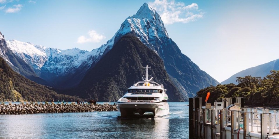 Boat cruise sailing through Milford Sound with Mitre Peak in the background